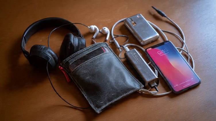 A small tech pouch containing a phone, charger, power bank, and headphones.jpg